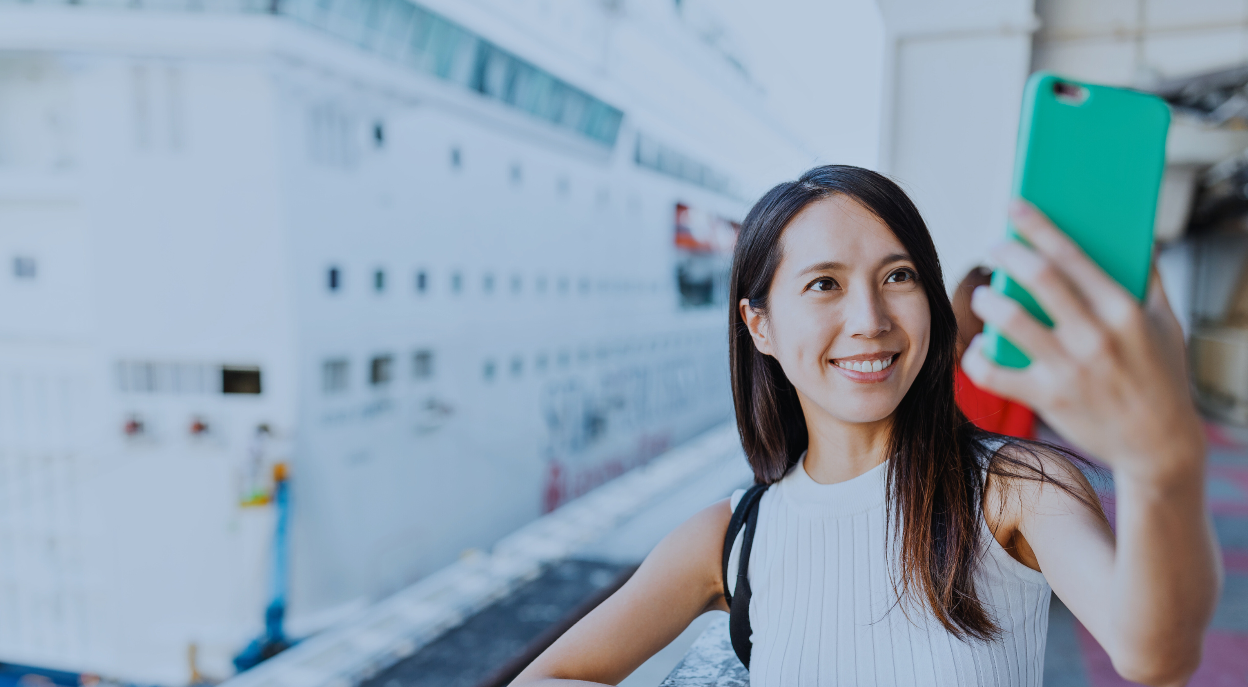 Woman taking a selfie in front of a cruise