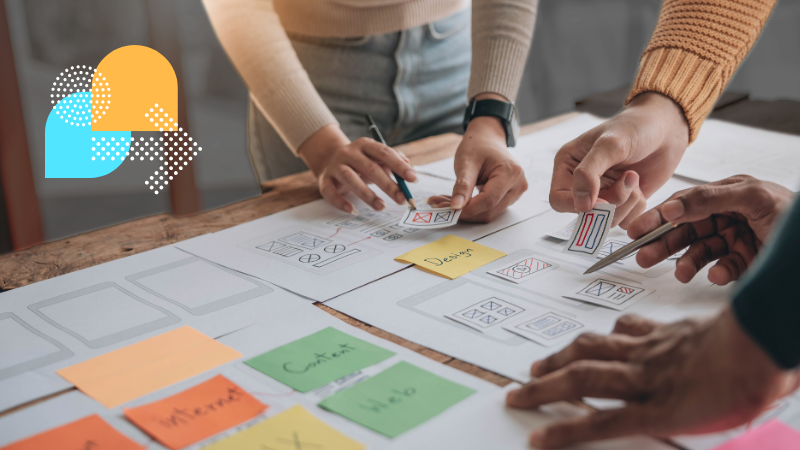 A group of people working on UX research, surrounded by sticky notes and other documents on a table.
