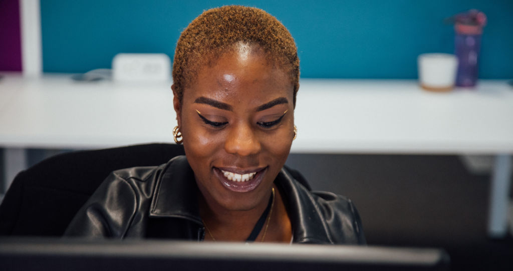 Woman looking on her desktop monitor and smiling